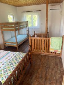 um quarto com 2 beliches e uma cadeira em Leto land Guest House em Pizunda