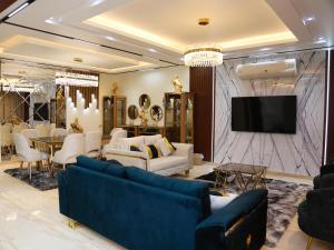 uma sala de estar com mobiliário azul e uma televisão em Royal Mansion with private pool in sheikh zayed Compound families em Sheikh Zayed