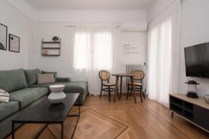 a living room with a green couch and a table at Vibrant Urban Getaway: Modern 1-Bedroom near Bars, Parks, and Metro in Athens