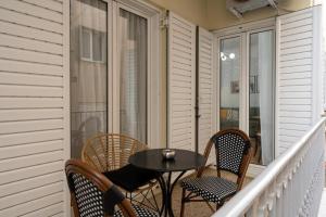un balcón con mesa y sillas en el porche en Vibrant Urban Getaway: Modern 1-Bedroom near Bars, Parks, and Metro, en Atenas
