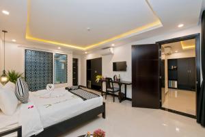 1 dormitorio con 1 cama y escritorio en una habitación en Gem Riverside Hotel Hoi An, en Hoi An