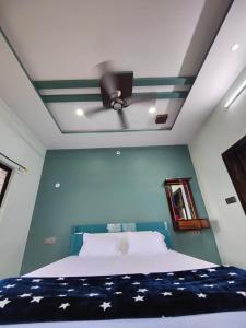 a bedroom with a bed with a ceiling fan at Aditya Tourist Home in Hampi