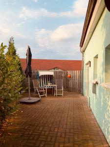un patio con sombrilla, mesa y sillas en Kleine Auszeit, en Rostock