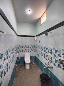 a bathroom with a toilet and a sink at Aditya Tourist Home in Hampi