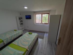 Habitación pequeña con 2 camas y ventana en Apartment Neo, en Bihać