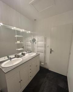 een badkamer met 2 wastafels en een grote spiegel bij Vigne et mer-Spacieux Appartement Haussmannien-2chambres-Wifi in Béziers