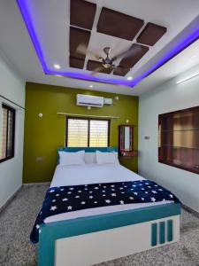 a bedroom with a bed and a ceiling with lights at Aditya Tourist Home in Hampi