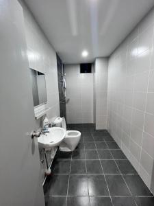 ein Bad mit einem Waschbecken und einem WC in der Unterkunft Qaisara Qais Homestay in Kuala Terengganu