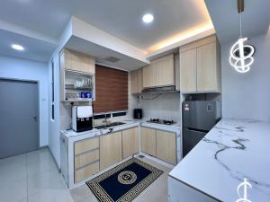 a kitchen with wooden cabinets and stainless steel appliances at Qaisara Qais Homestay in Kuala Terengganu