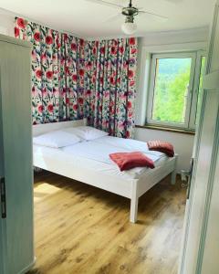 een slaapkamer met een bed met een gordijn en een raam bij zaKRZYWEk retro in Cisna