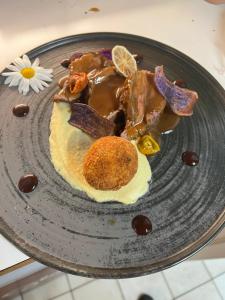 a plate of food with a dessert on a table at Hotel und Restaurant Alpina in Savognin