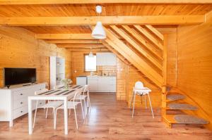 a kitchen and dining room with a table and chairs at Domki LUX in Jarosławiec
