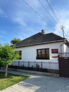 una casa blanca con una valla delante en Gyongyver Panzio, en Sfântu-Gheorghe
