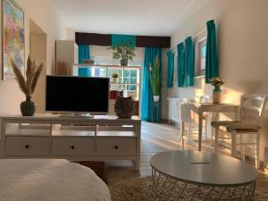 una sala de estar con TV de pantalla plana en un armario en Kleine Auszeit, en Rostock