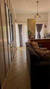 a living room with a couch and a kitchen at Charming 1 bedroom house with garden view in Nairobi! in Nairobi