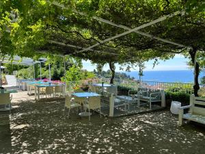 een groep tafels en stoelen met de oceaan op de achtergrond bij VISTA del MAR in Piran