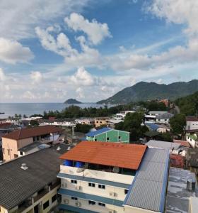 a city with buildings and the ocean in the background at Bluegelatohousekohtao in Ko Tao