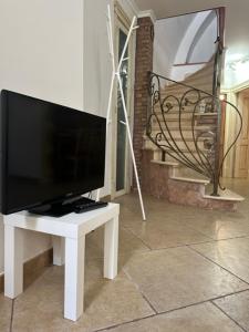 uma televisão sentada numa mesa branca numa sala de estar em Casa vacanze Conte Cavour em Laterza