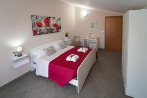 - une chambre avec un grand lit blanc et une couverture rouge dans l'établissement Villa Falcone, à Alvignano