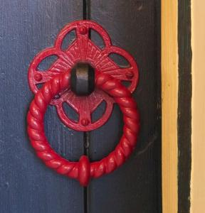 a red wreath is on a black door at The Sunday Schoolroom in Sherborne