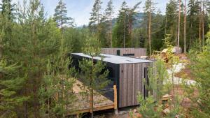 a timber clad house in the woods at Grend-hytte in Bø