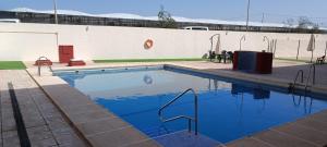 uma piscina com água azul em frente a um edifício em Ático en Buenavista playa em Roquetas de Mar