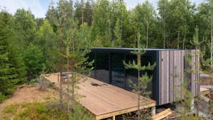 una casa en el bosque con una terraza de madera en Grend-hytte en Bø