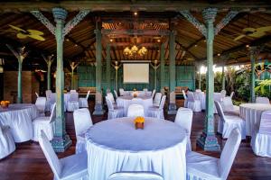 a banquet hall with white tables and white chairs at Arya Arkananta Resort & Spa in Ubud