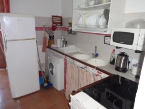 william house في لوس كانيوس دي ميكا: مطبخ مع ثلاجة بيضاء وغسالة ملابس