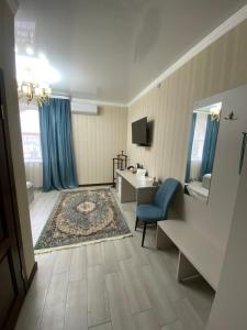 a room with a bathroom with a sink and a desk at Hotel Astam in Kostanay