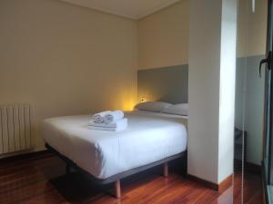 een slaapkamer met een bed met handdoeken erop bij 3B.Descansa y disfruta en el corazón de las Burgas in Ourense