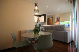 een woonkamer met een tafel en stoelen en een bank bij 3B.Descansa y disfruta en el corazón de las Burgas in Ourense