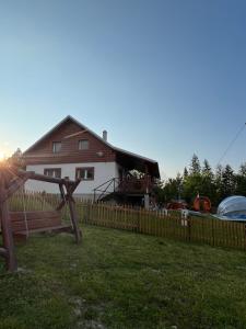 ein Haus mit einem Zaun davor in der Unterkunft Wellness chata Kozička in Klokočov