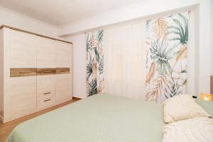 ein Schlafzimmer mit einem Bett und einer Kommode in der Unterkunft Apartamento Máximo in Torrevieja