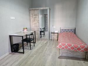 a bedroom with a bed and a desk and a table at Nihol in Tashkent