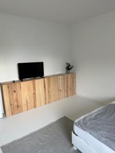 a bedroom with a tv on a white wall at Casa Móre GRAY in Niederalm