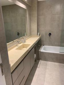 a bathroom with two sinks and a tub and a mirror at Duplex Lujan Mendoza cercanía Chacras de Coria in Ciudad Lujan de Cuyo
