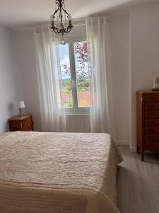 a bedroom with a large bed and a window at Maison au coeur du Périgord Vert in Javerlhac-et-la-Chapelle-Saint-Robert