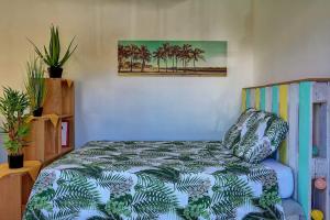 a bedroom with a bed with palm trees on it at Studio La Tortue in Saint-Gilles les Bains