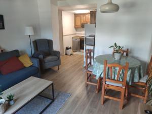 a living room with a table and a blue couch at Apartamento en Benasque in Benasque