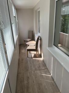 um corredor com uma cadeira, uma mesa e uma janela em Vanilės home em Siauliai
