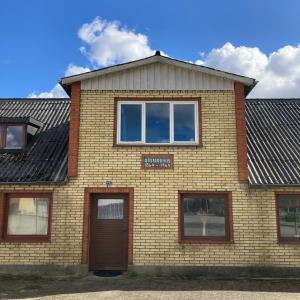 um edifício de tijolos com uma porta castanha e janelas em Døssinghus Holiday Apartments em Kjellerup