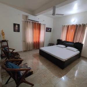 1 dormitorio con 1 cama y 2 sillas en The Olive Greens en Pāonta Sāhib