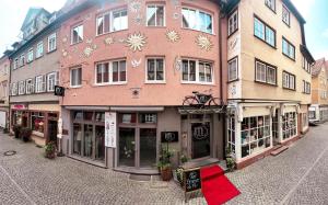 a building with a red rug in front of it at Hotel am Malerwinkel in Wertheim