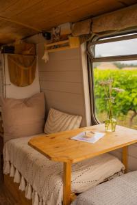 een houten tafel in een tiny house met een raam bij Nuit insolite au milieu des vignes in Goult