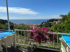 uma varanda com flores cor-de-rosa numa cerca branca em VISTA del MAR em Piran