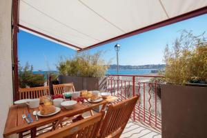アンティーブにあるMAISON MARINA - Absoluty Antibes - New-Luxury old Antibes - 1st Row Sea View Terraceの木製テーブル(バルコニーの上に食べ物付)