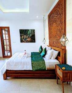 Un dormitorio con una cama grande con cabecero de madera. en Villa Na-Na Ubud, en Ubud 10 fotos más
