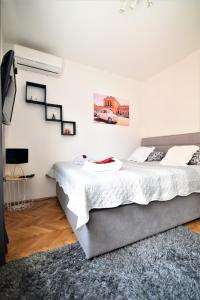 a white bedroom with a bed and a tv at GretaNola studio in Zagreb, parking, self check-in in Zagreb
