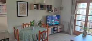 貝納斯克的住宿－Apartamento en Benasque，一间带桌子和电视的用餐室